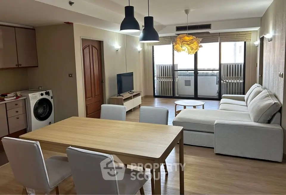 Spacious living room with modern furniture and balcony access in a stylish apartment.