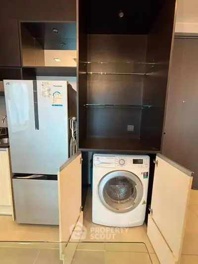 Modern kitchen with integrated washing machine and sleek fridge