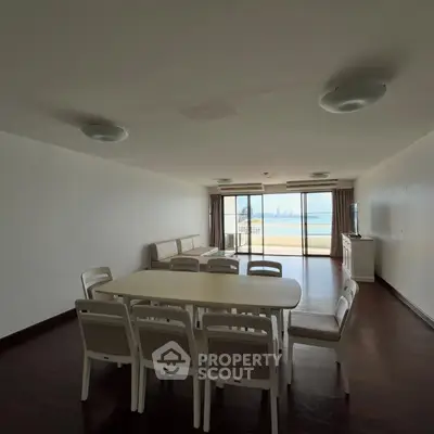 Spacious living room with dining area and stunning ocean view through large windows.
