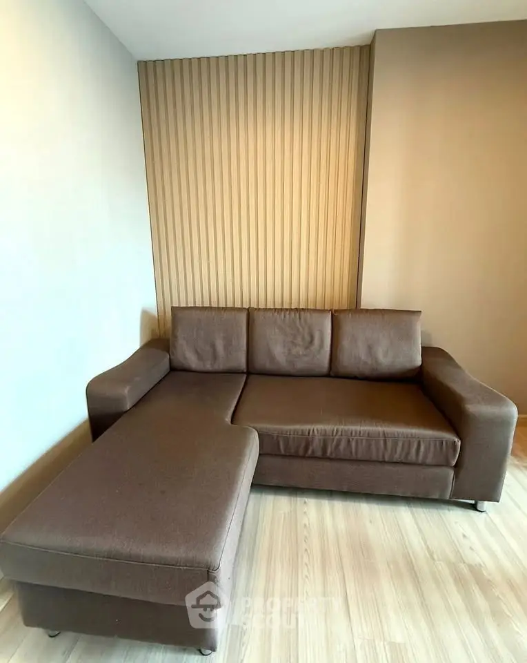 Modern living room with stylish brown sectional sofa and wooden accent wall