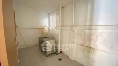 Spacious utility room with sink, ideal for storage or laundry setup.