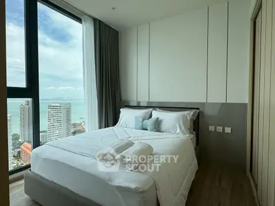 Luxurious bedroom with stunning ocean view in modern high-rise apartment.