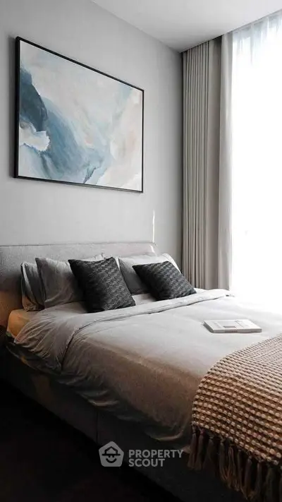 Elegant bedroom with modern decor and large window for natural light.