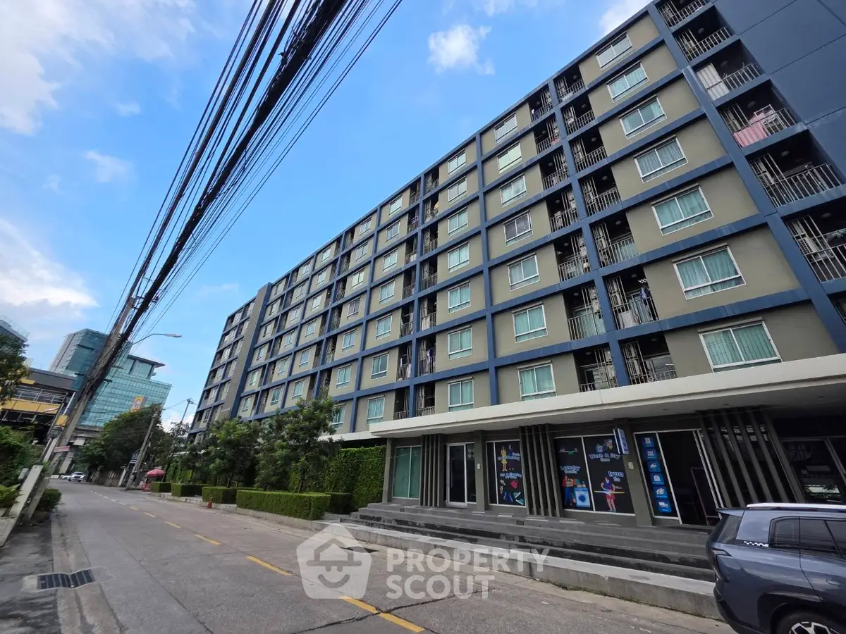 Modern multi-story apartment building with street view and clear blue sky