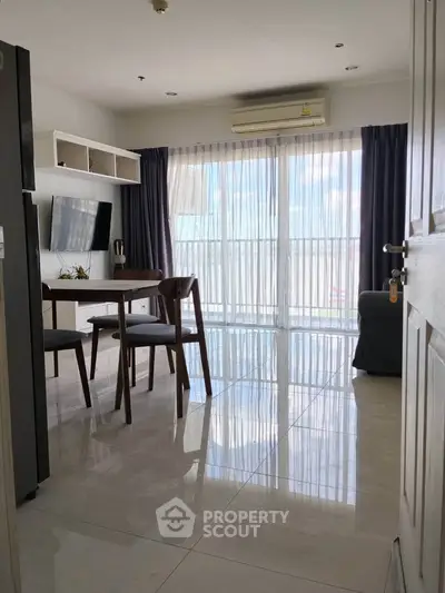 Modern living room with large windows and sleek furniture, offering abundant natural light and a cozy atmosphere.