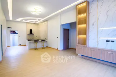 Spacious modern living room with open kitchen and elegant lighting