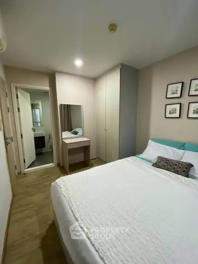 Cozy bedroom with modern decor and ensuite bathroom in a stylish apartment.