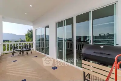 Spacious balcony with stunning mountain views and outdoor dining area, perfect for relaxation and entertainment.