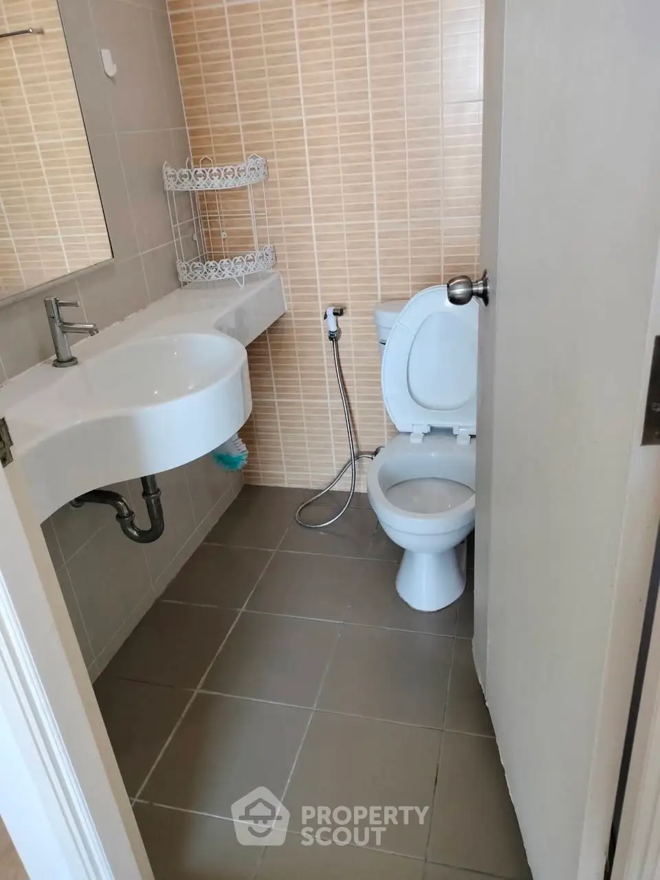 Compact bathroom with modern fixtures and neutral tiles