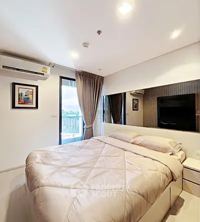 Modern bedroom with balcony access and stylish decor in a high-rise apartment.