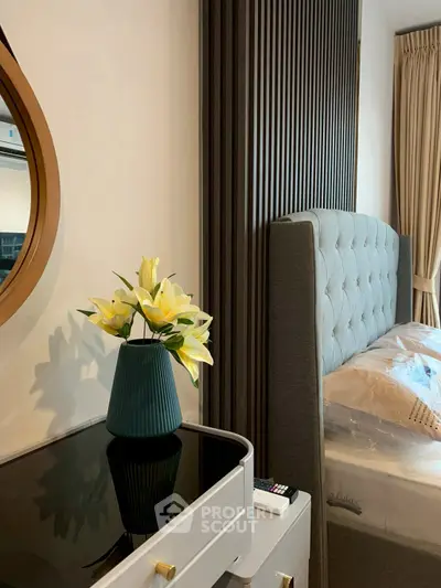 Elegant bedroom with modern decor and stylish furniture, featuring a plush bed and decorative vase.