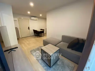 Modern living room with cozy sofa and dining area in open layout apartment.