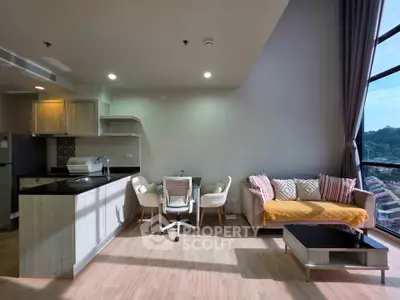 Modern open-plan living room with kitchen, large windows, and stylish furniture