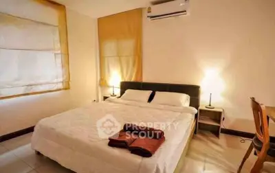 Cozy bedroom with warm lighting and modern furnishings, perfect for relaxation.