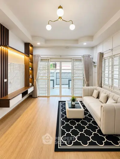 Elegant living room with modern decor and large windows opening to a balcony.