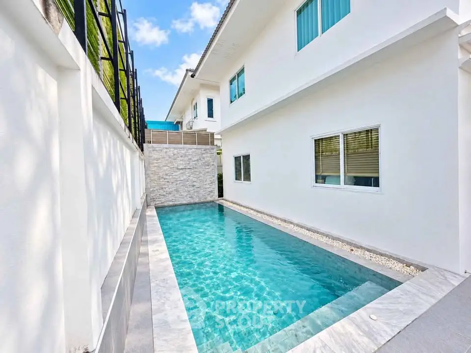 Luxurious modern home with private swimming pool and sleek white exterior.