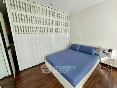 Modern bedroom with sleek design and wooden flooring, featuring a comfortable bed and stylish decor.