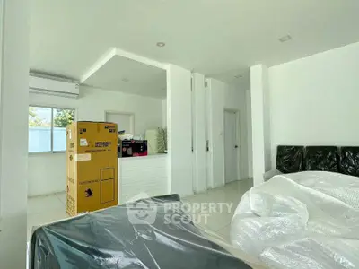 Spacious living room with modern appliances and sleek white interior design.