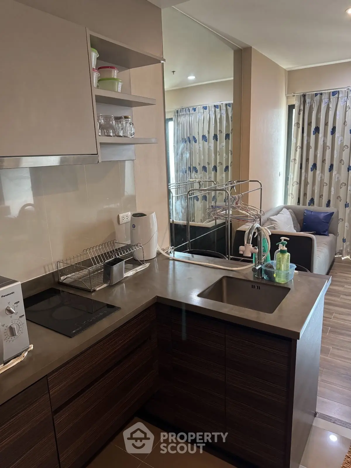Modern kitchen with sleek design and open layout leading to cozy living area.