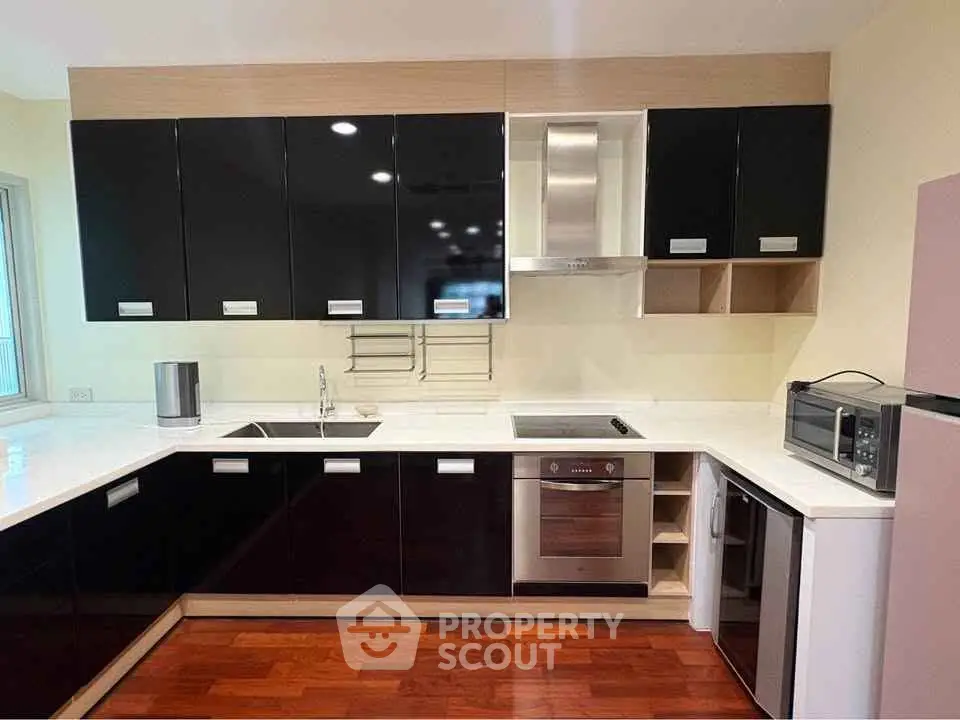 Modern kitchen with sleek black cabinets and stainless steel appliances
