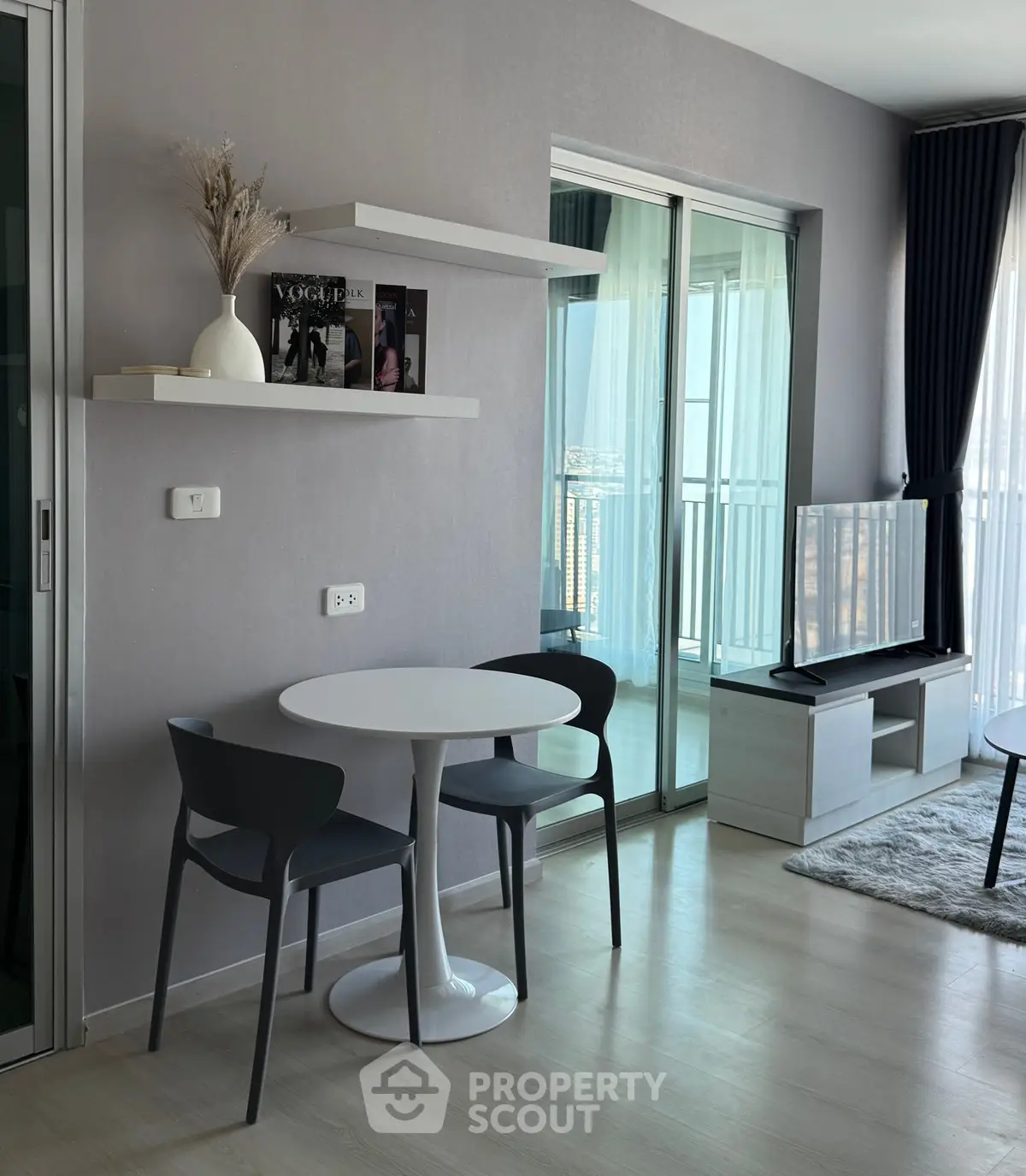 Modern living room with balcony view, sleek furniture, and stylish decor