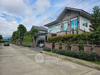 Modern suburban house with lush garden and driveway in a serene neighborhood.