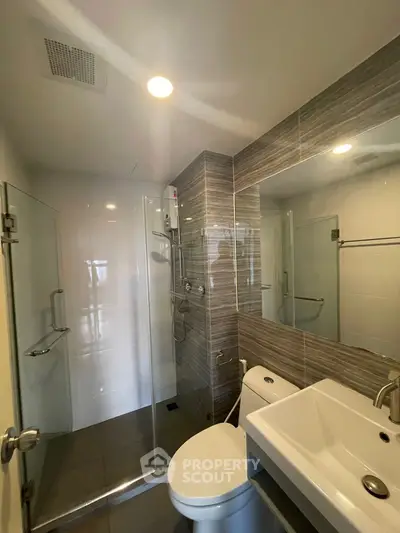 Modern bathroom with glass shower and sleek fixtures in a contemporary apartment.
