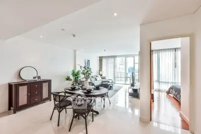Spacious open-plan living and dining area with modern decor and city view.