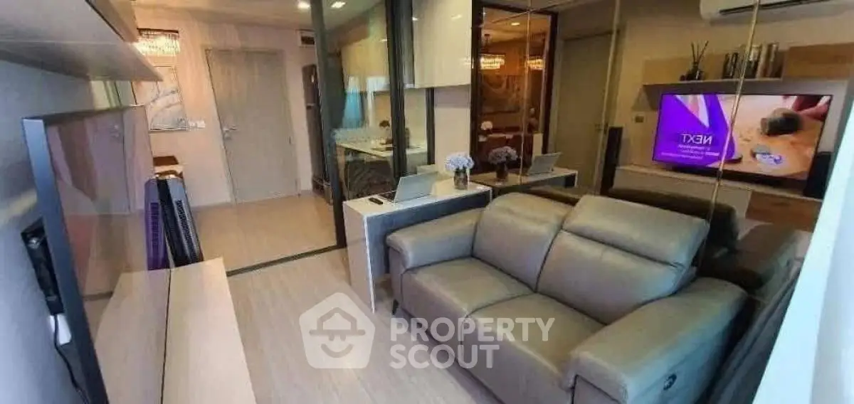 Modern living room with sleek furniture and large TV, perfect for relaxation.