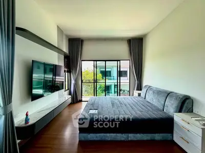 Spacious modern bedroom with large window and stylish decor, offering a serene view and ample natural light.