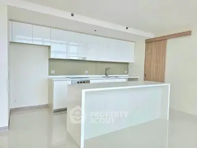 Modern kitchen with sleek white cabinets and island in open layout design.
