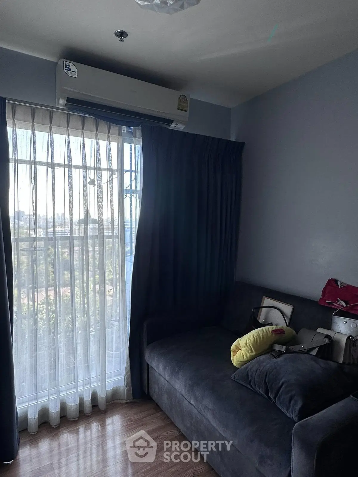 Cozy living room with large window and modern air conditioning unit, perfect for relaxation.