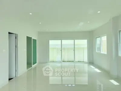 Spacious modern living room with large windows and glossy tiled floors