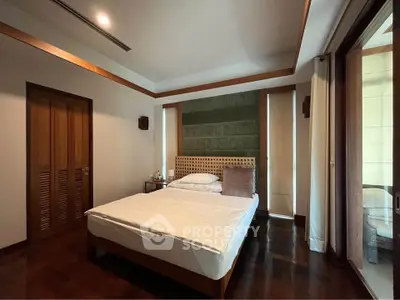 Spacious bedroom with elegant wooden accents and large windows for natural light.