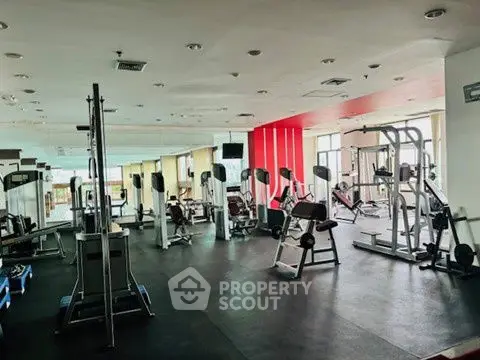 Spacious modern gym with state-of-the-art fitness equipment and natural lighting.