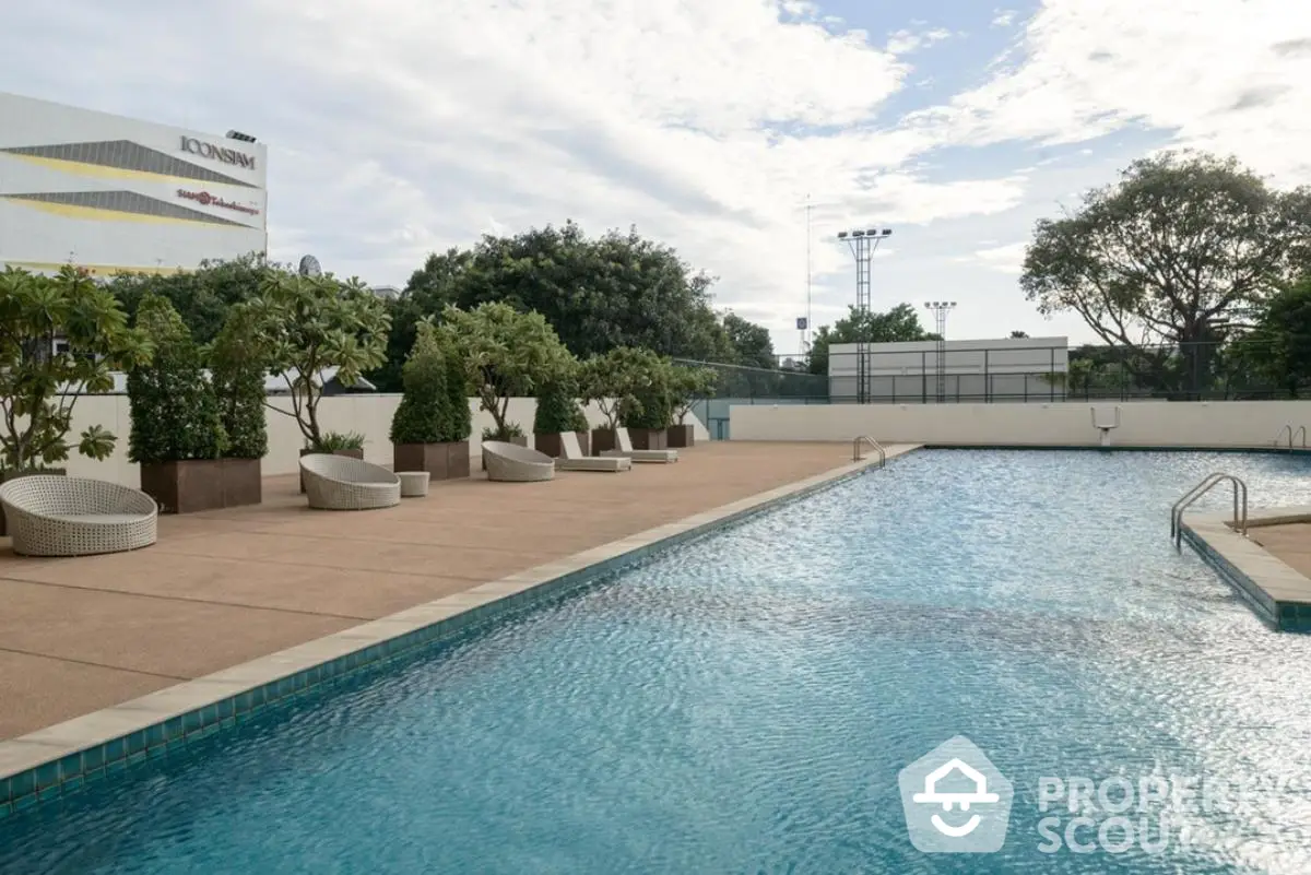 Luxurious outdoor swimming pool with modern seating and lush greenery