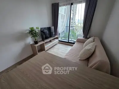 Modern living room with cozy sofa, TV, and balcony view in stylish apartment.
