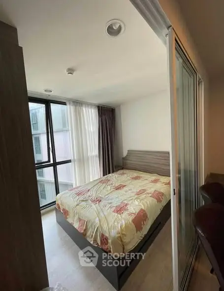 Modern bedroom with large windows and stylish decor in a high-rise apartment.