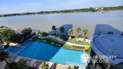 Stunning riverside view with luxurious pool and lush garden in modern residential complex.