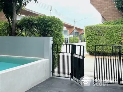 Modern gated entrance with lush greenery and sleek design