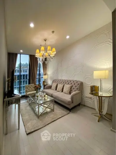 Elegant living room with plush sofa, chandelier, and large window offering natural light and city view.