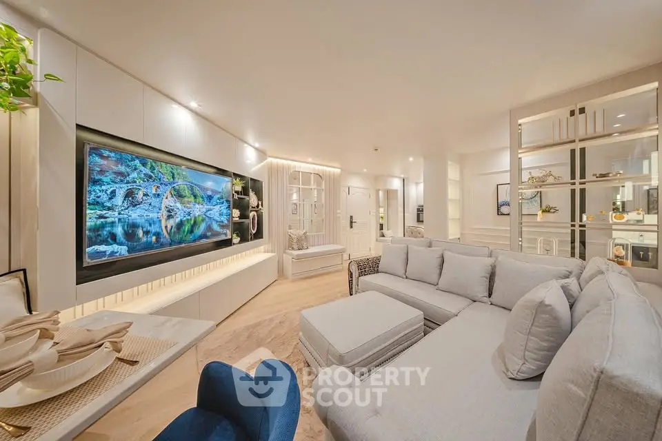 Luxurious modern living room with elegant decor and large TV, perfect for relaxation and entertainment.