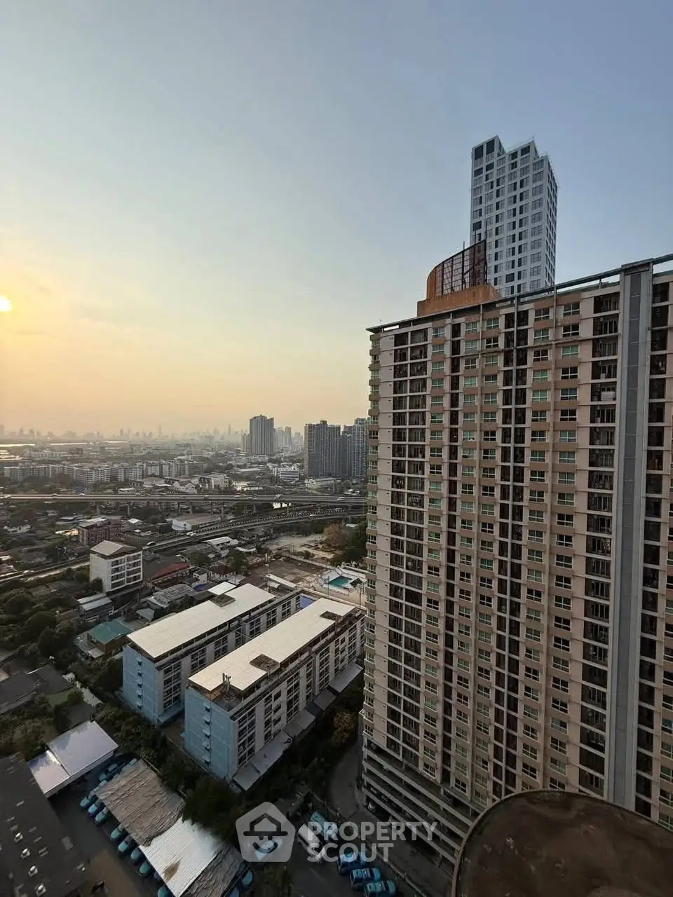 Stunning cityscape view from high-rise apartment balcony at sunset
