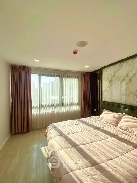 Bright and cozy bedroom with large window and elegant decor