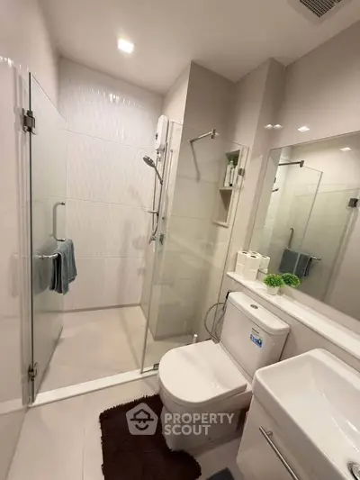 Modern bathroom with glass shower, sleek fixtures, and elegant design.