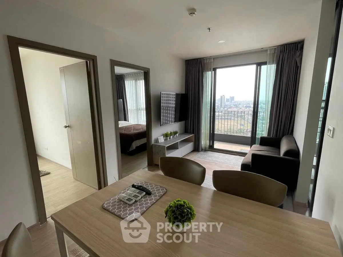 Modern living room with city view, stylish furniture, and natural light.