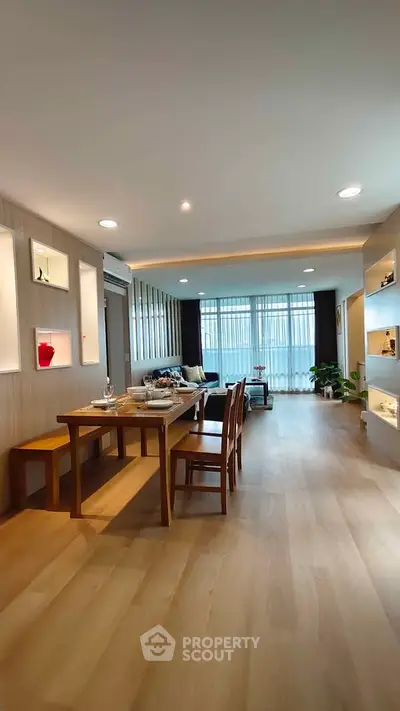 Spacious modern living room with dining area, wooden flooring, and elegant decor.