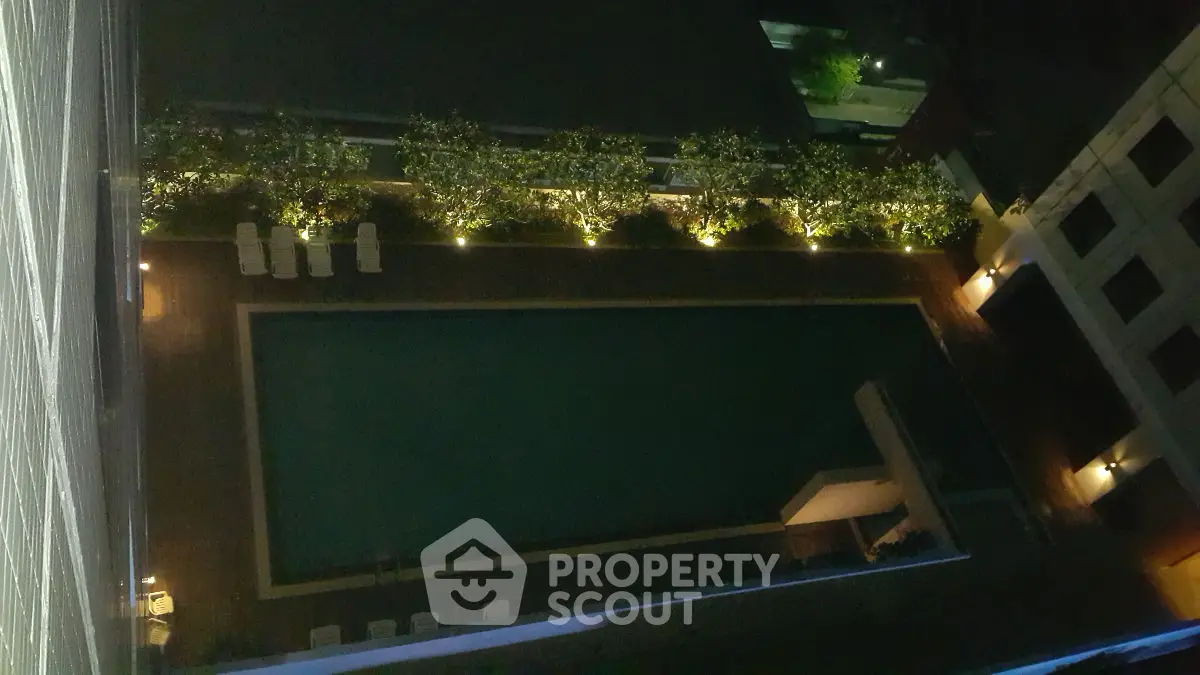 Stunning aerial view of illuminated rooftop pool at night, perfect for luxury living.