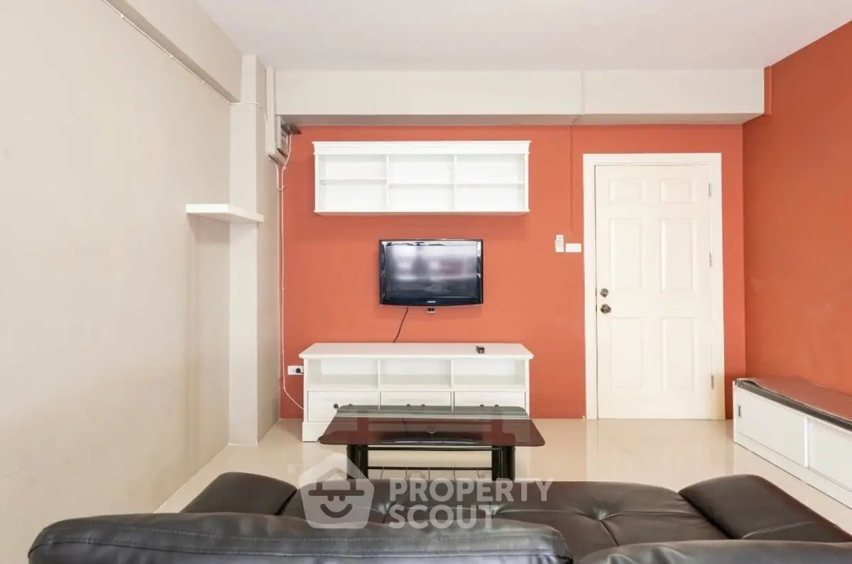 Modern living room with sleek furniture and wall-mounted TV, perfect for relaxation and entertainment.