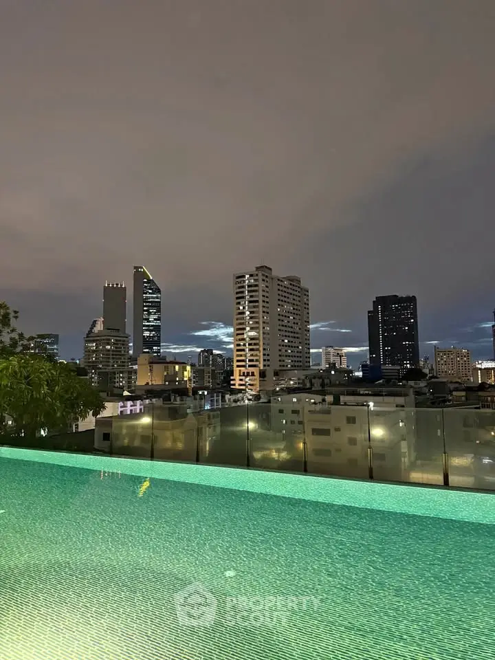 Stunning rooftop pool with breathtaking city skyline view at dusk.